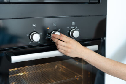 Woman Select Program Turning Switch At Modern Built In Oven